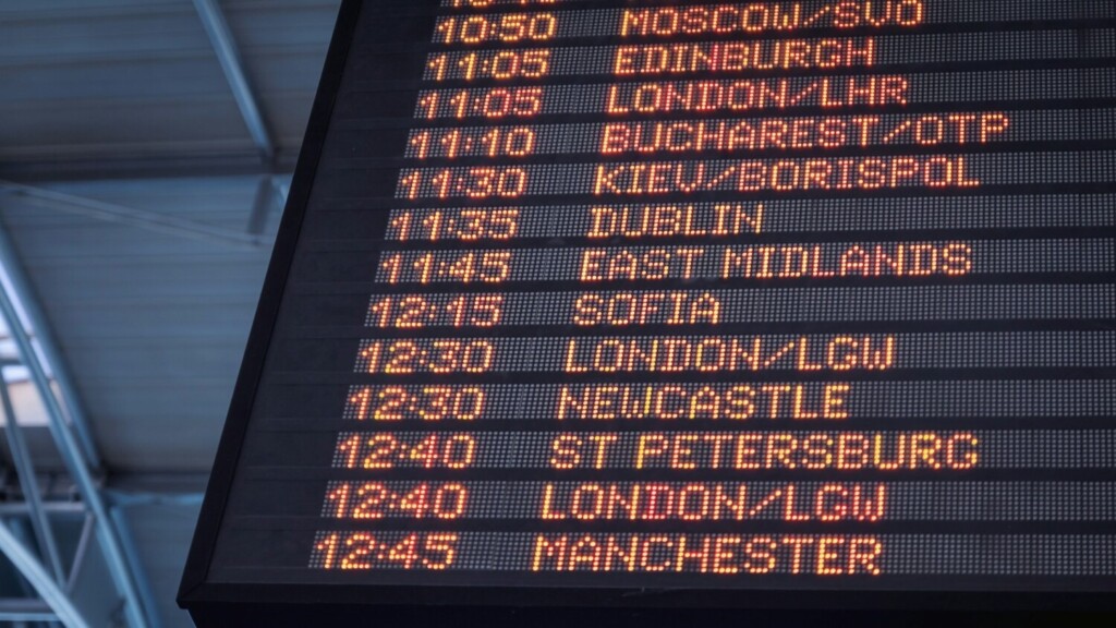 Luchthavenbord toont e.t.a.'s van internationale vluchten met aankomsttijden in oranje LED-letters