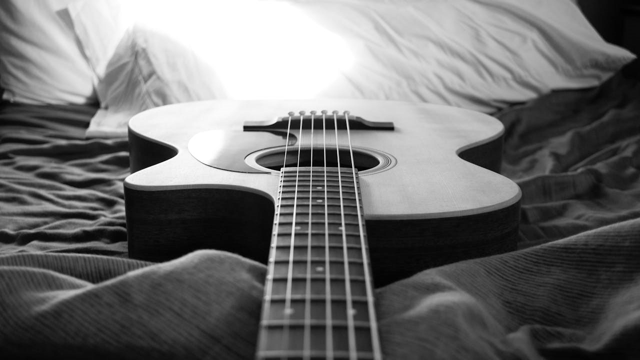 Akoestiek beïnvloed door een akoestische gitaar die op een bed ligt met zachte stoffen en kussens