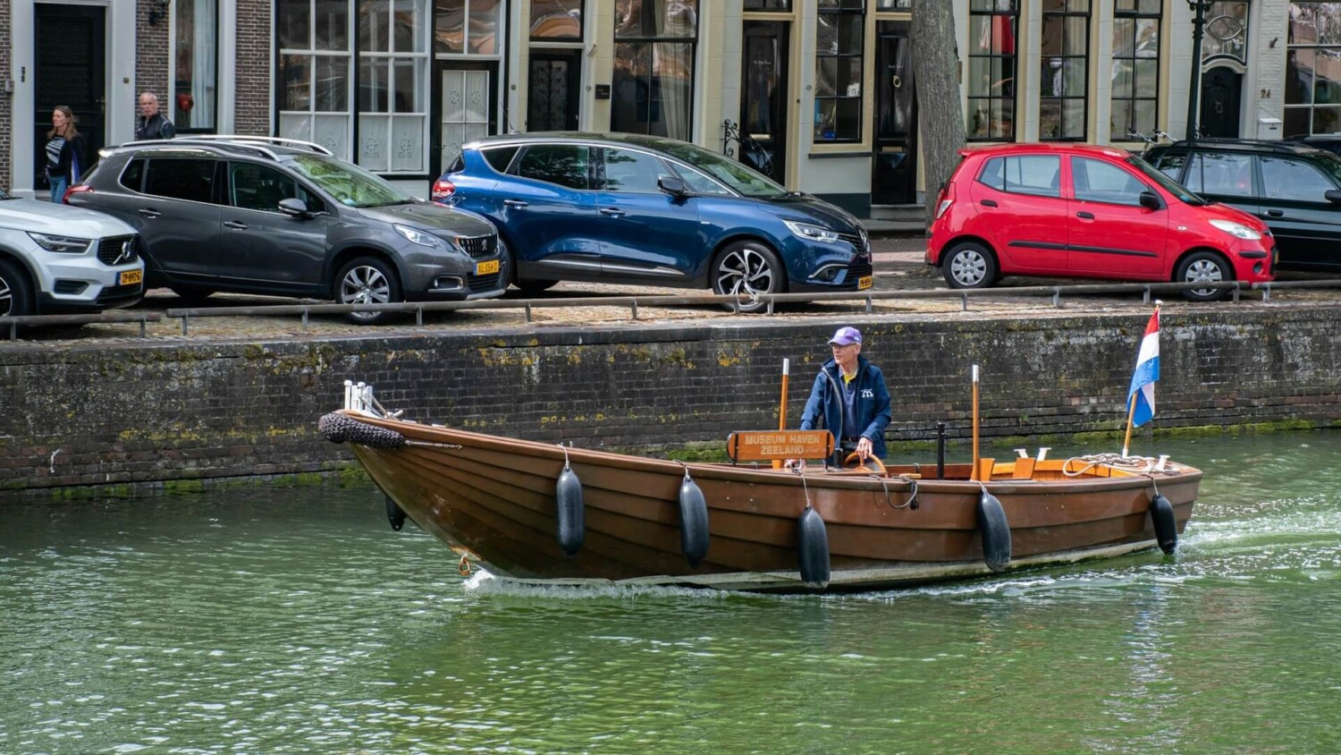 Traditionele sloep vaart door een Nederlandse gracht tijdens recreatief gebruik op binnenwateren.