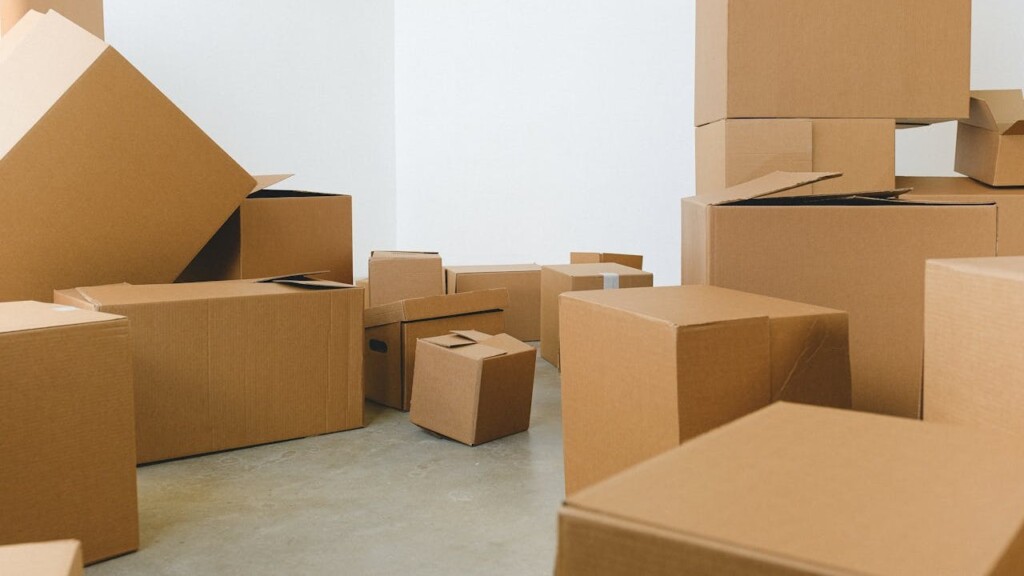 Stapels kartonnen verhuisdozen in lege ruimte bij voorbereiding op verhuizing met verhuisgarantie