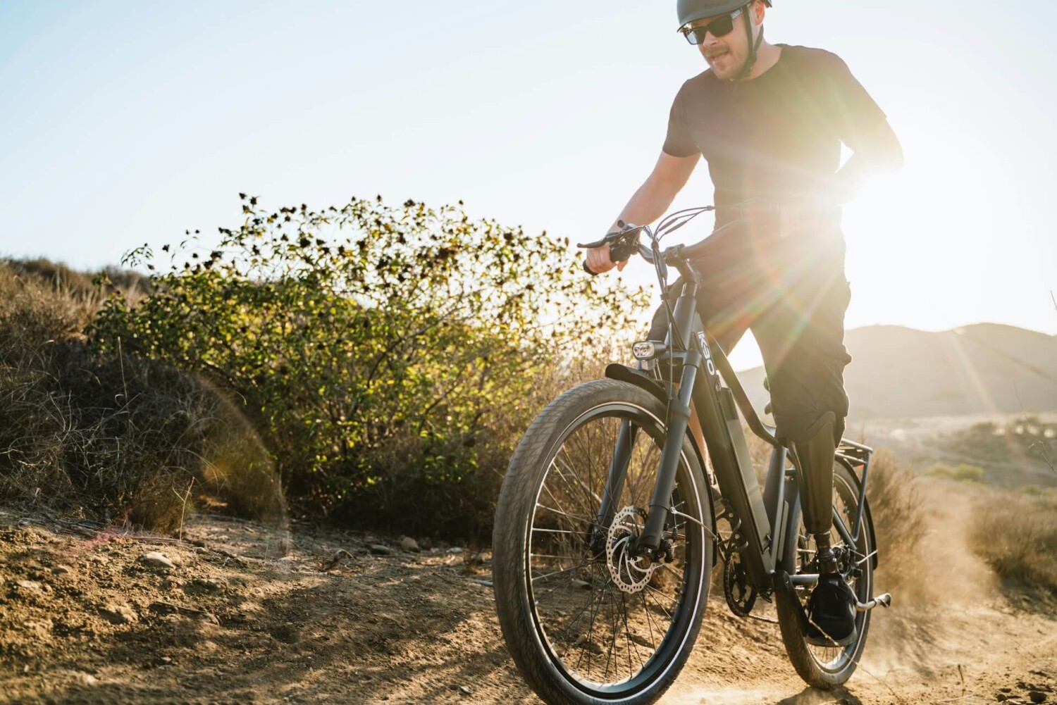 Fietser op een e-bike in heuvelachtig terrein, waar actieradius bij e-bikes wordt be&iuml;nvloed door hoogteverschillen