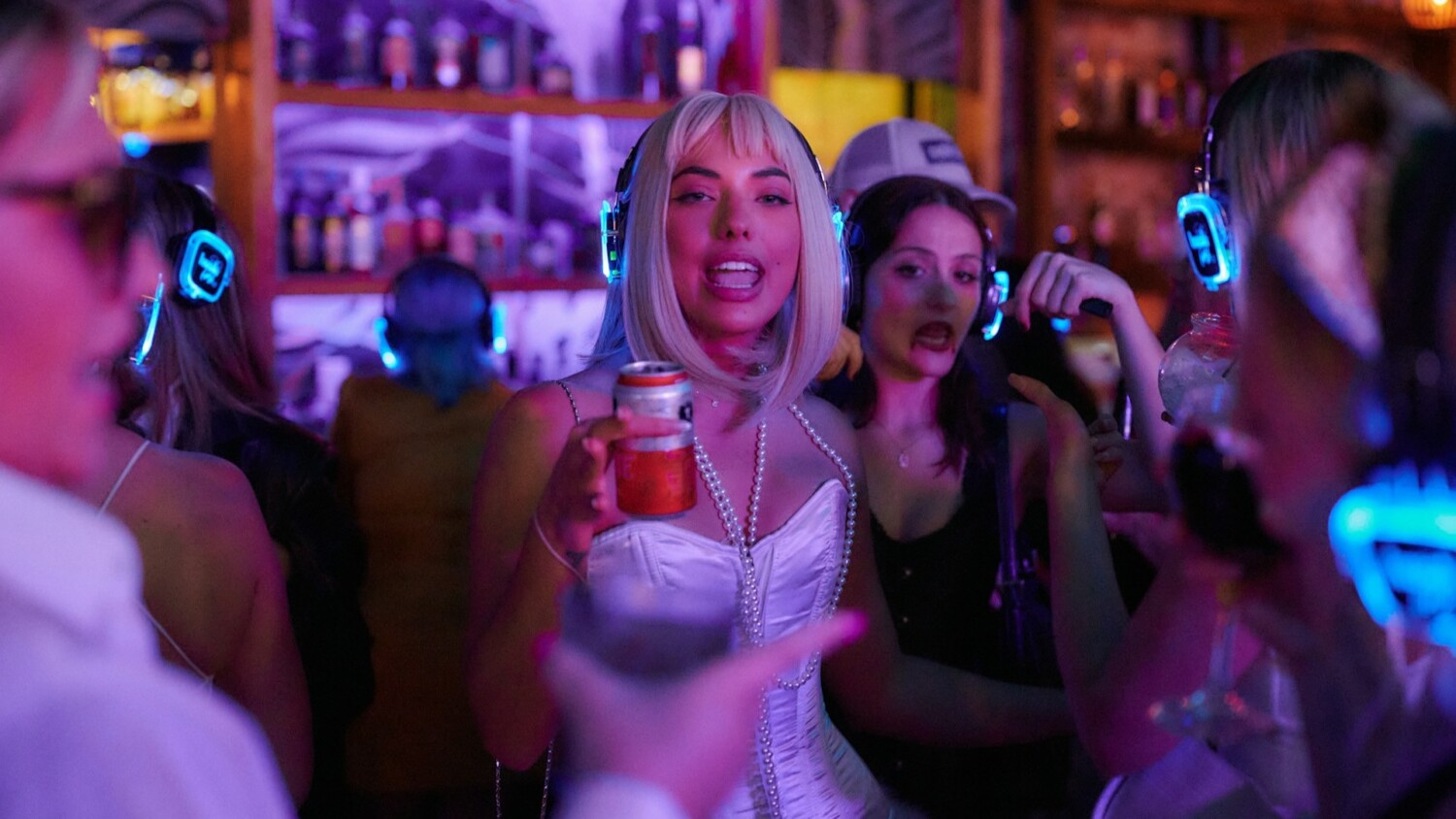 Groep feestgangers met drankjes en koptelefoons tijdens een levendige silent disco-avond